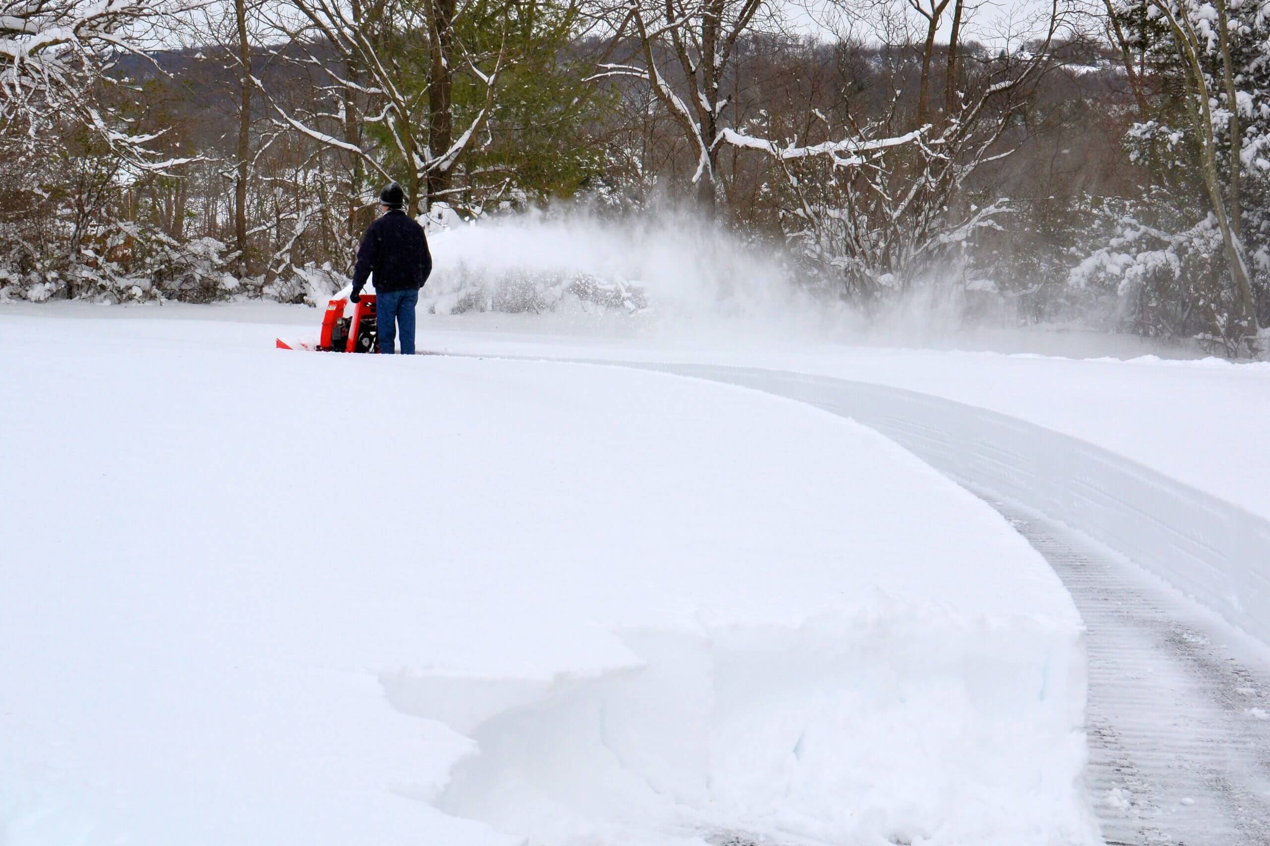 Man clearing snow with snow blower